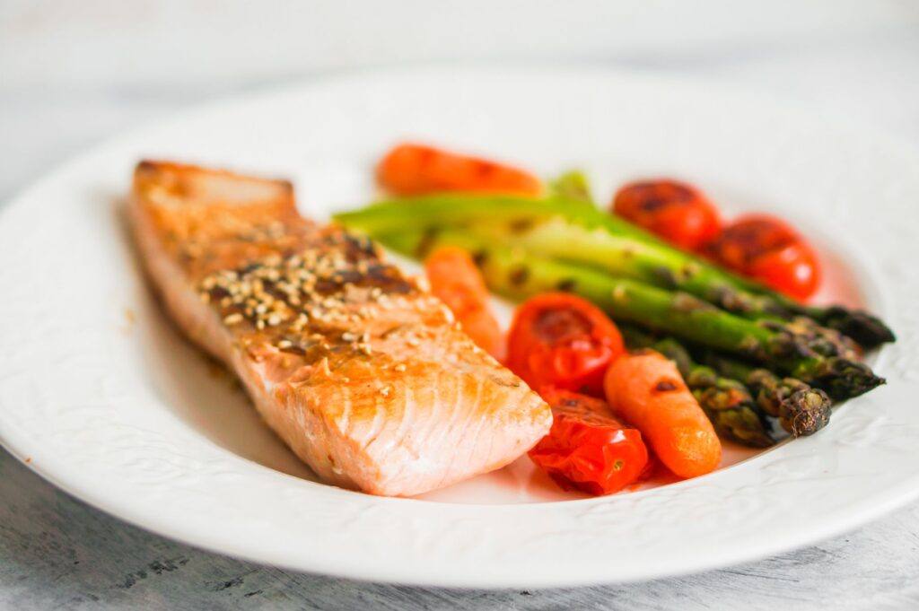 balanced diet consisting of salmon, asparagus, tomatoes, and carrot. 