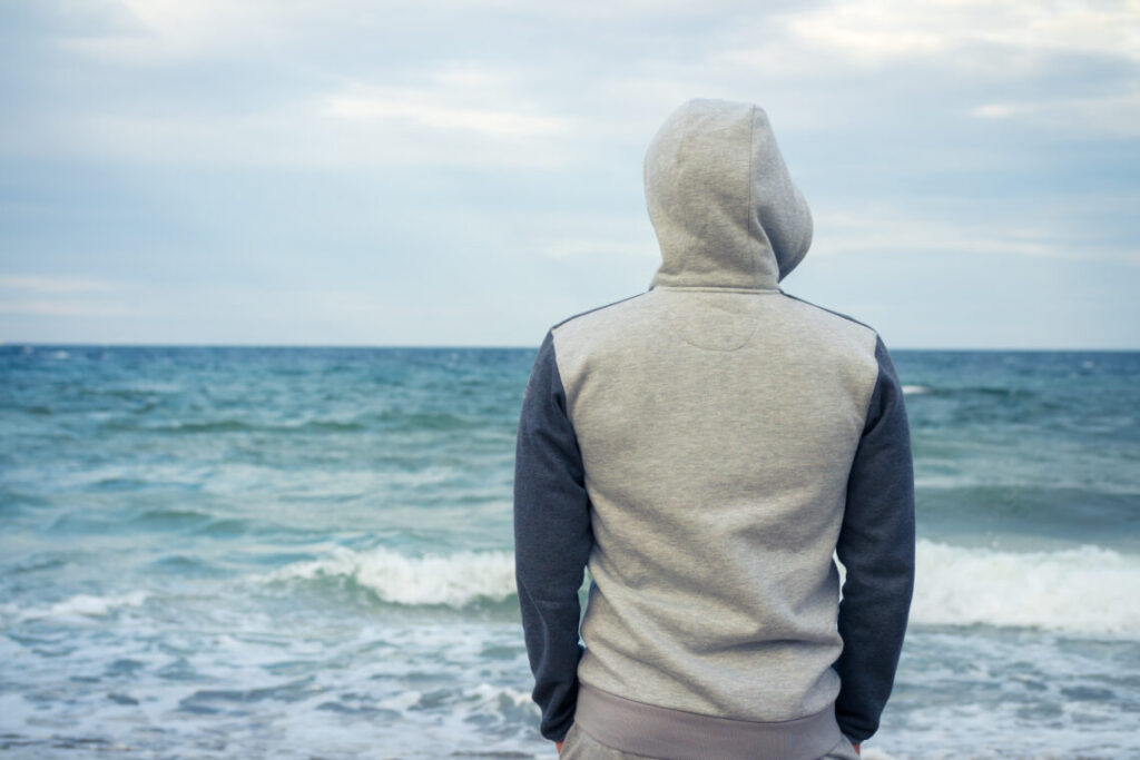 lonely man staring out at the sea